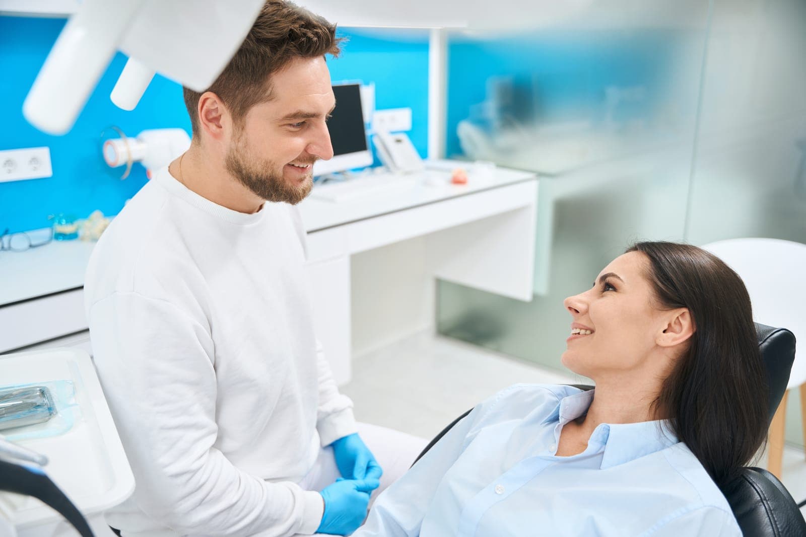 Dentist Smiling and Talking to Patient in Modern Clinic