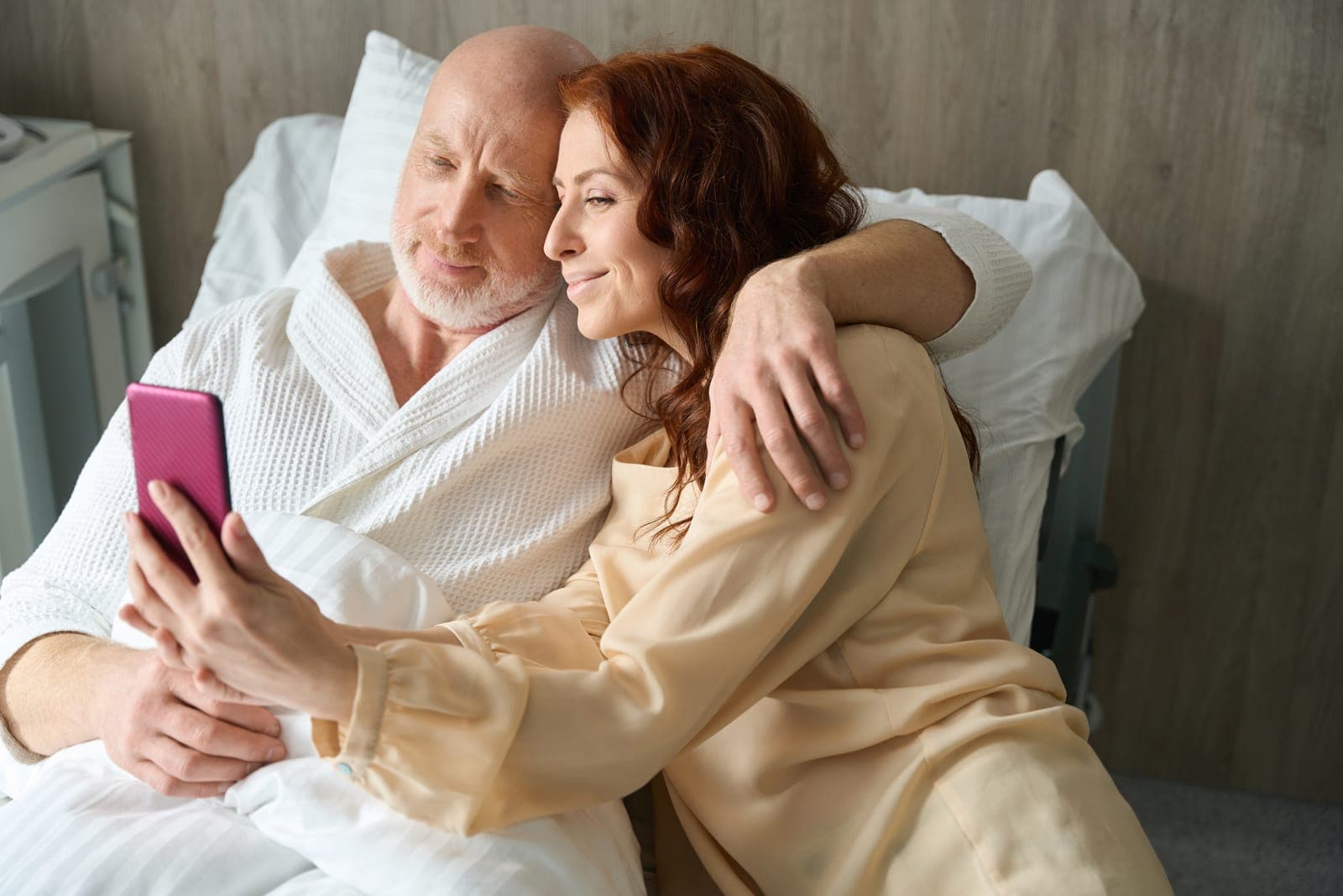 Middle-aged Couple Relaxing in Bed with Smartphone