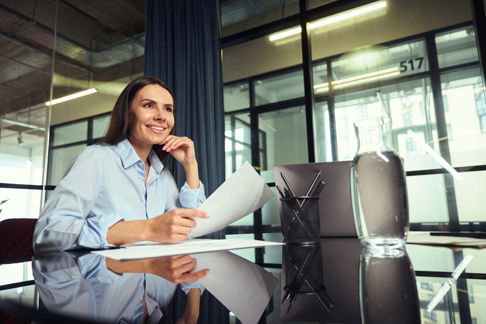 Smiling Woman Working at Desk in Modern Office