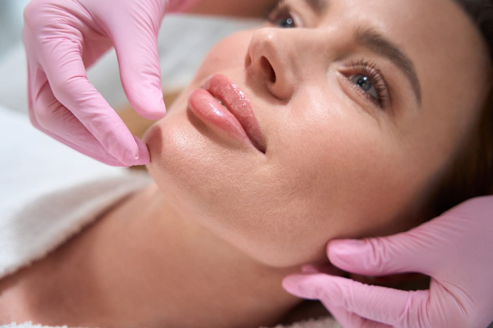 Woman Receiving Cosmetic Treatment with Pink Gloves